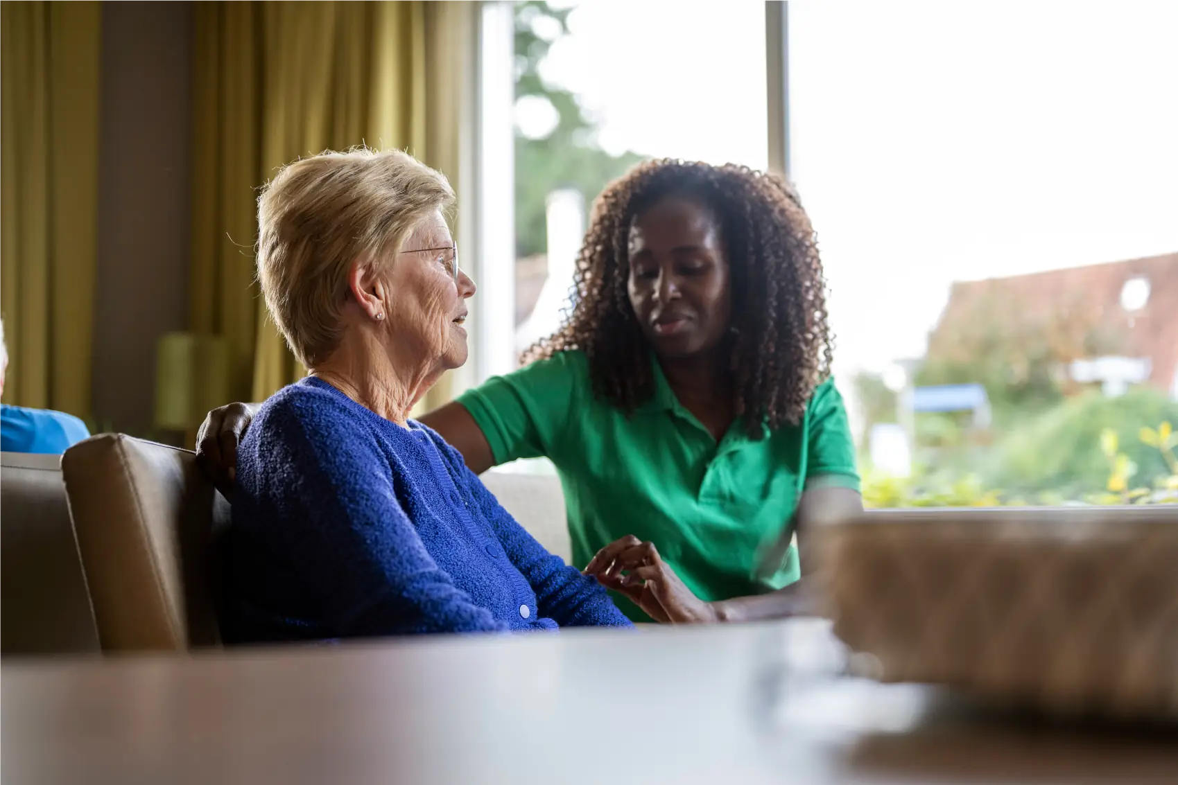 Carer supporting elderly woman with companionship and emotional support at home in Sussex and Surrey