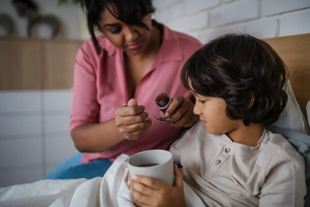 Parent giving medicine to a child at home with care and reassurance