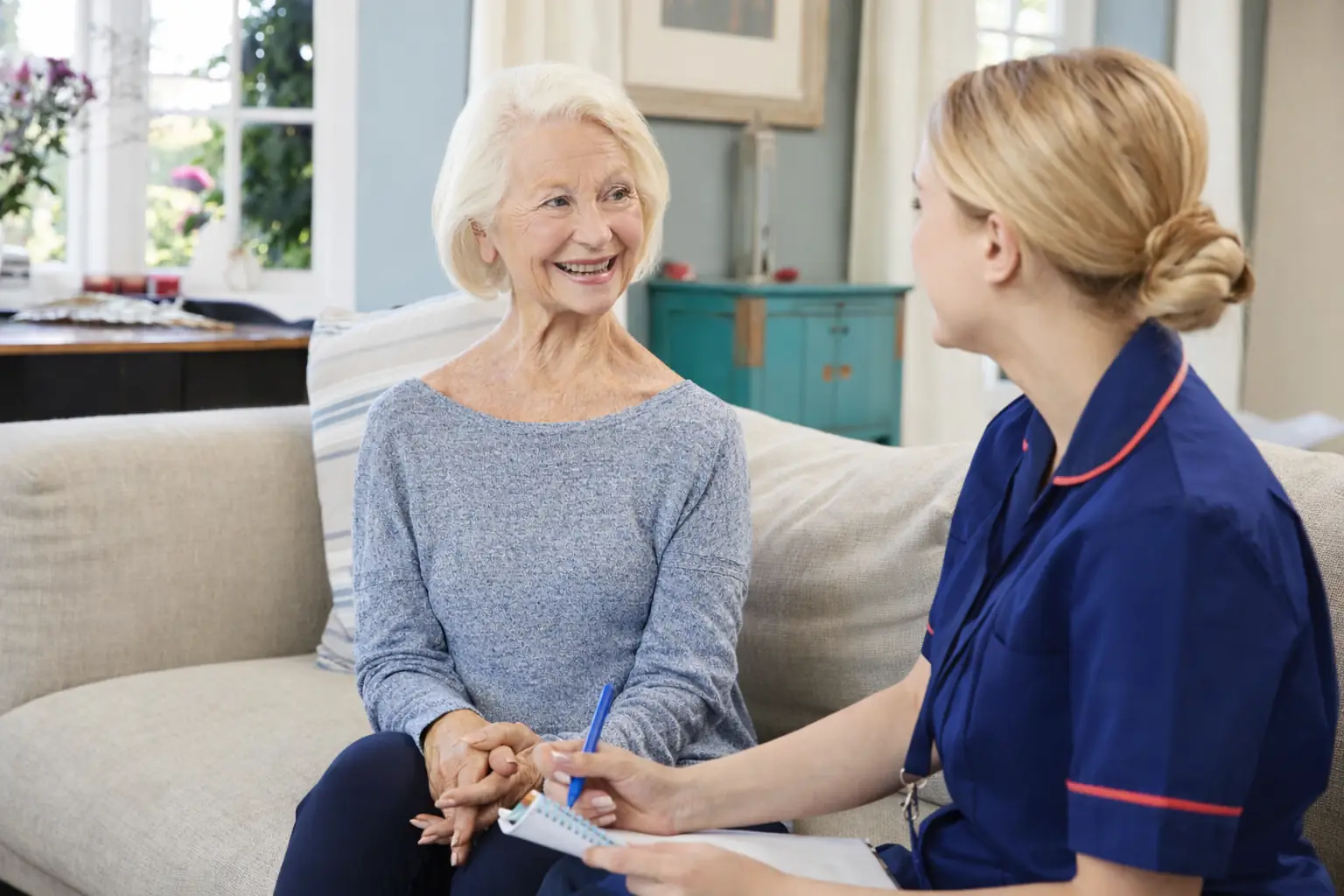 Nurse discussing care plan with elderly woman at home in Sussex and Surrey