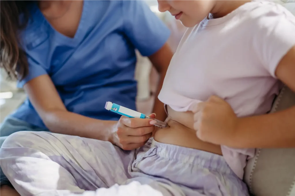 Healthcare professional supporting a child with insulin administration at home